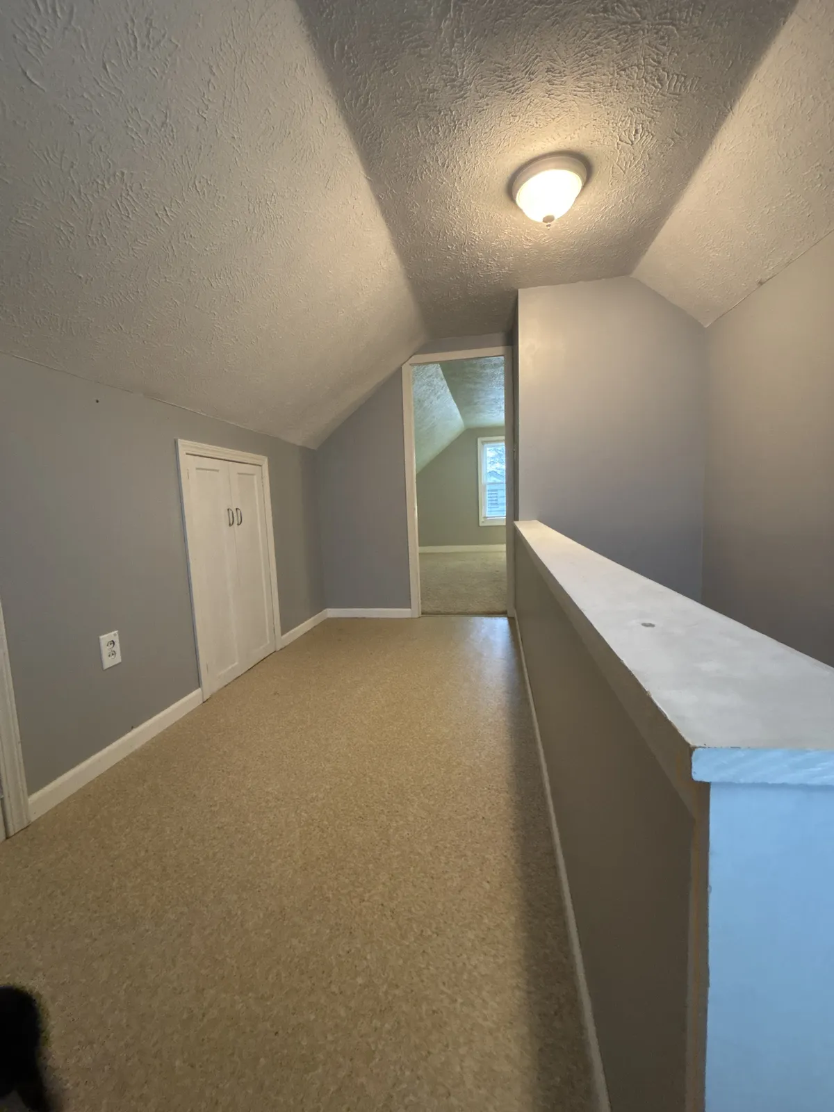 Upstairs hallway with half wall and no railing